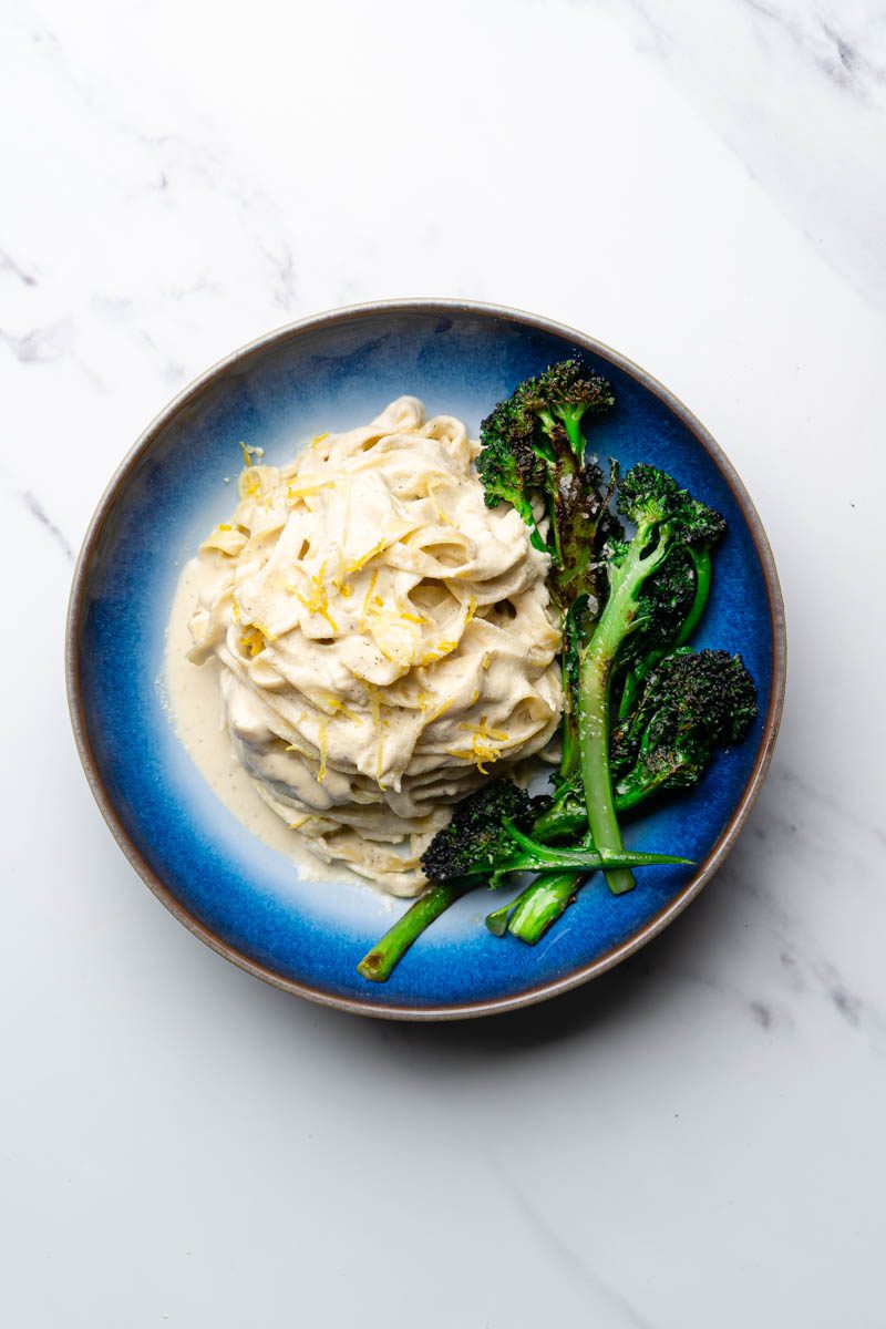 creamy vegan lemon and broccoli pasta in bowl on table
