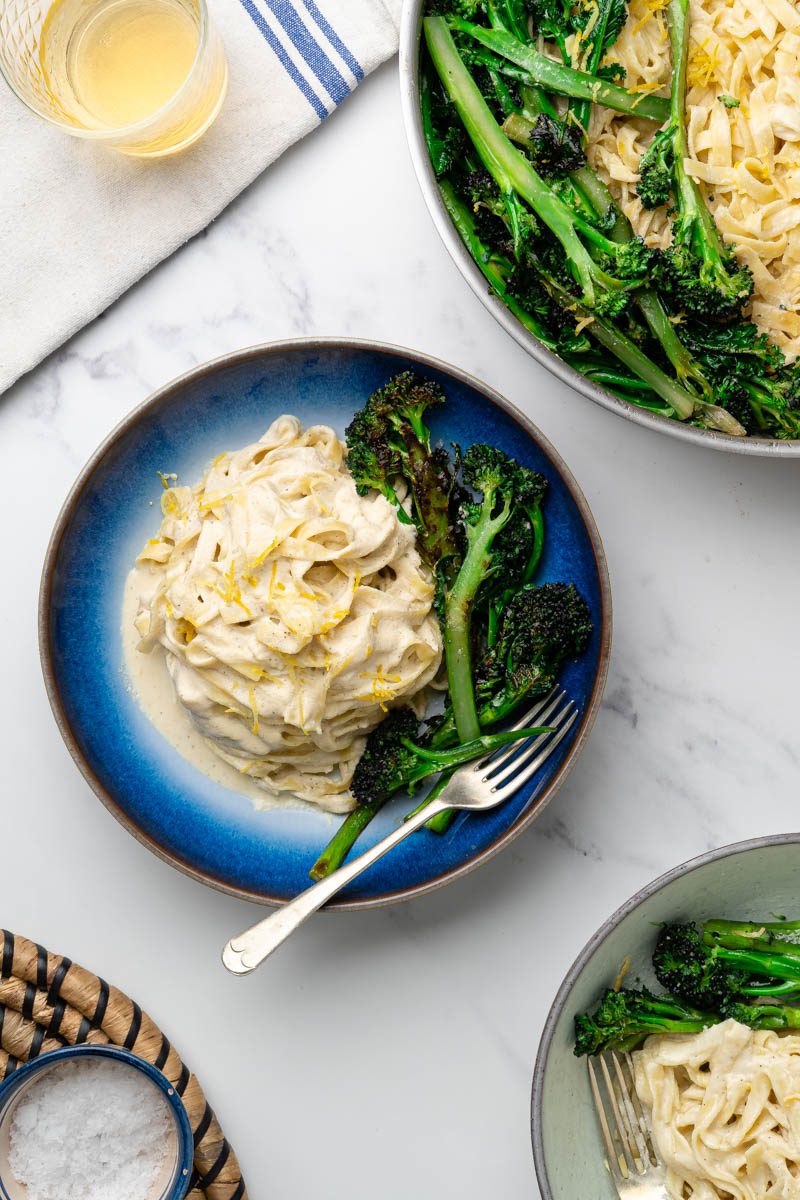 creamy vegan lemon and broccoli pasta with plates on table